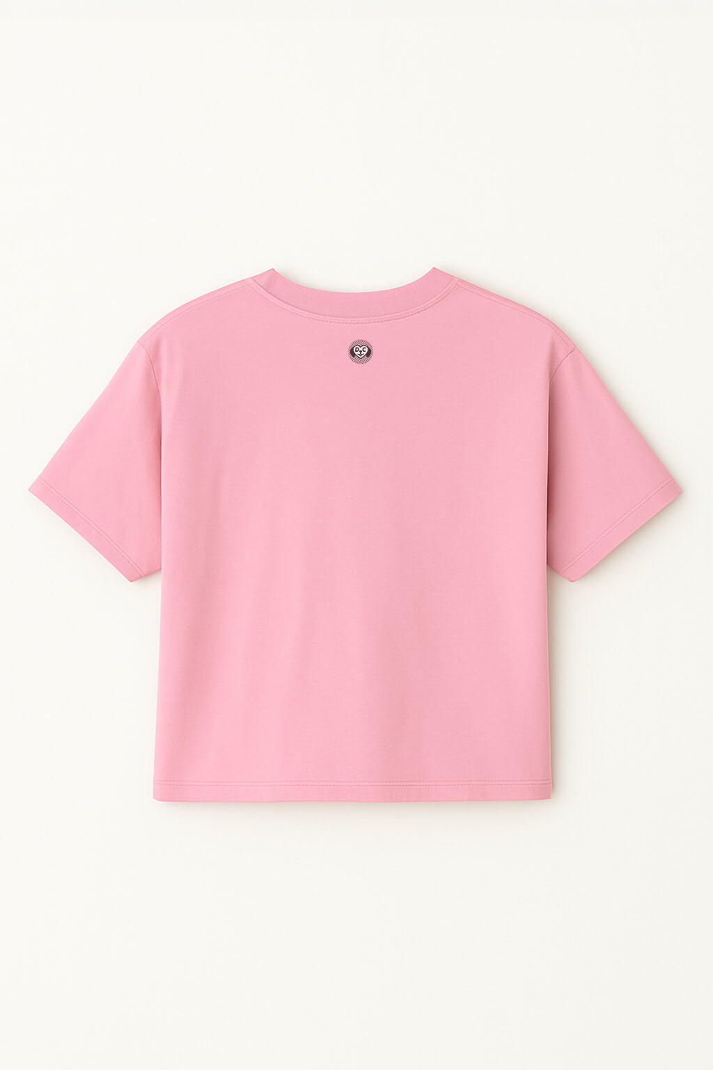 The Oversized Dog Mom Crop Top by Dogloverclothing.com is a plain pink combed cotton crop top with a small circular logo near the back neckline, perfect for embracing a relaxed, comfortable style.
