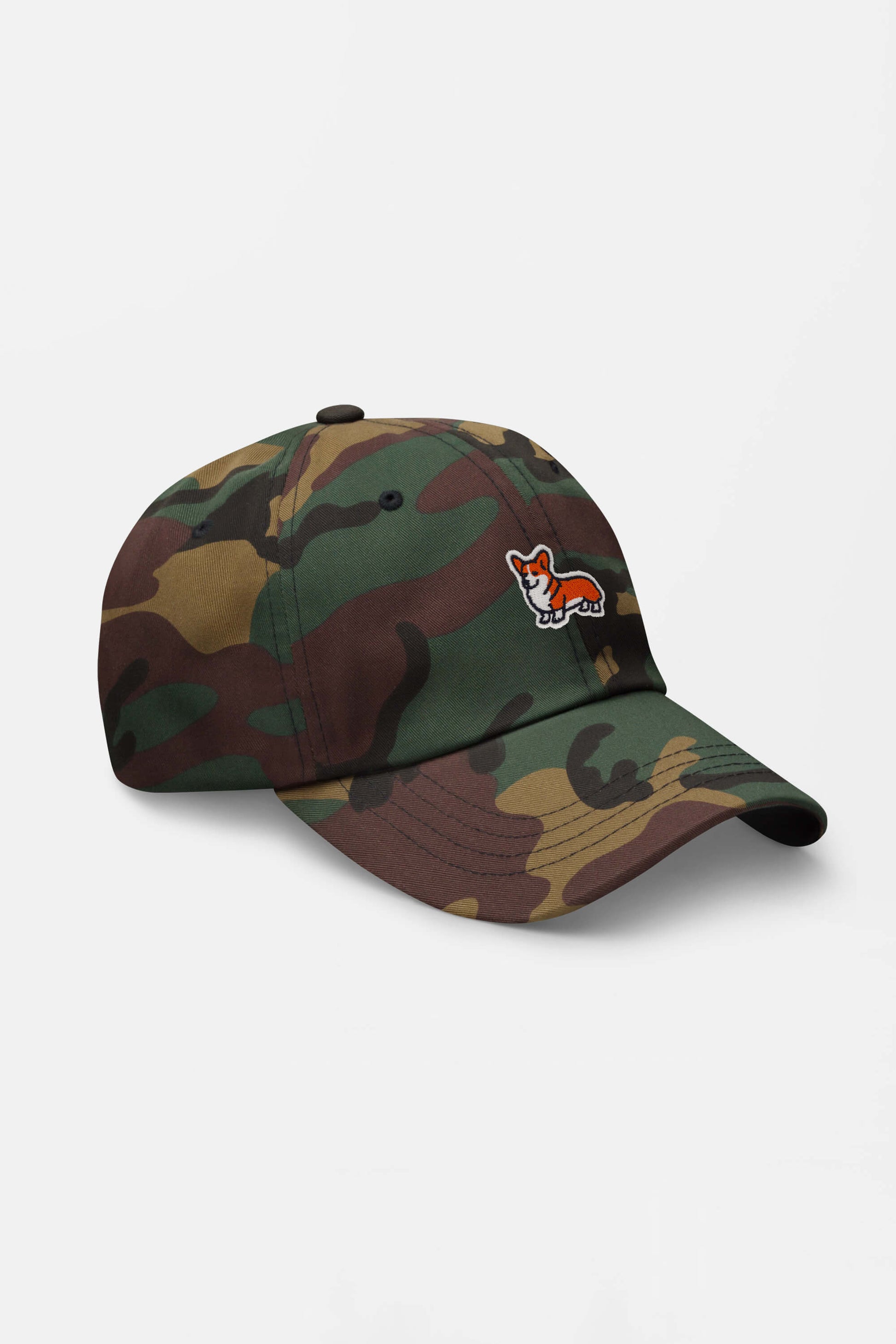 The Iconic Corgi Cap by Dogloverclothing.com features a small embroidered corgi on its camouflage design, adding cute style. Shown against a plain white background.