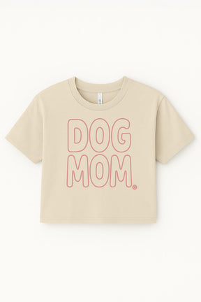 The Oversized Dog Mom Crop Top from Dogloverclothing.com features bold, outlined pink DOG MOM. lettering on beige—perfect for showing off your Dog Mom lifestyle.