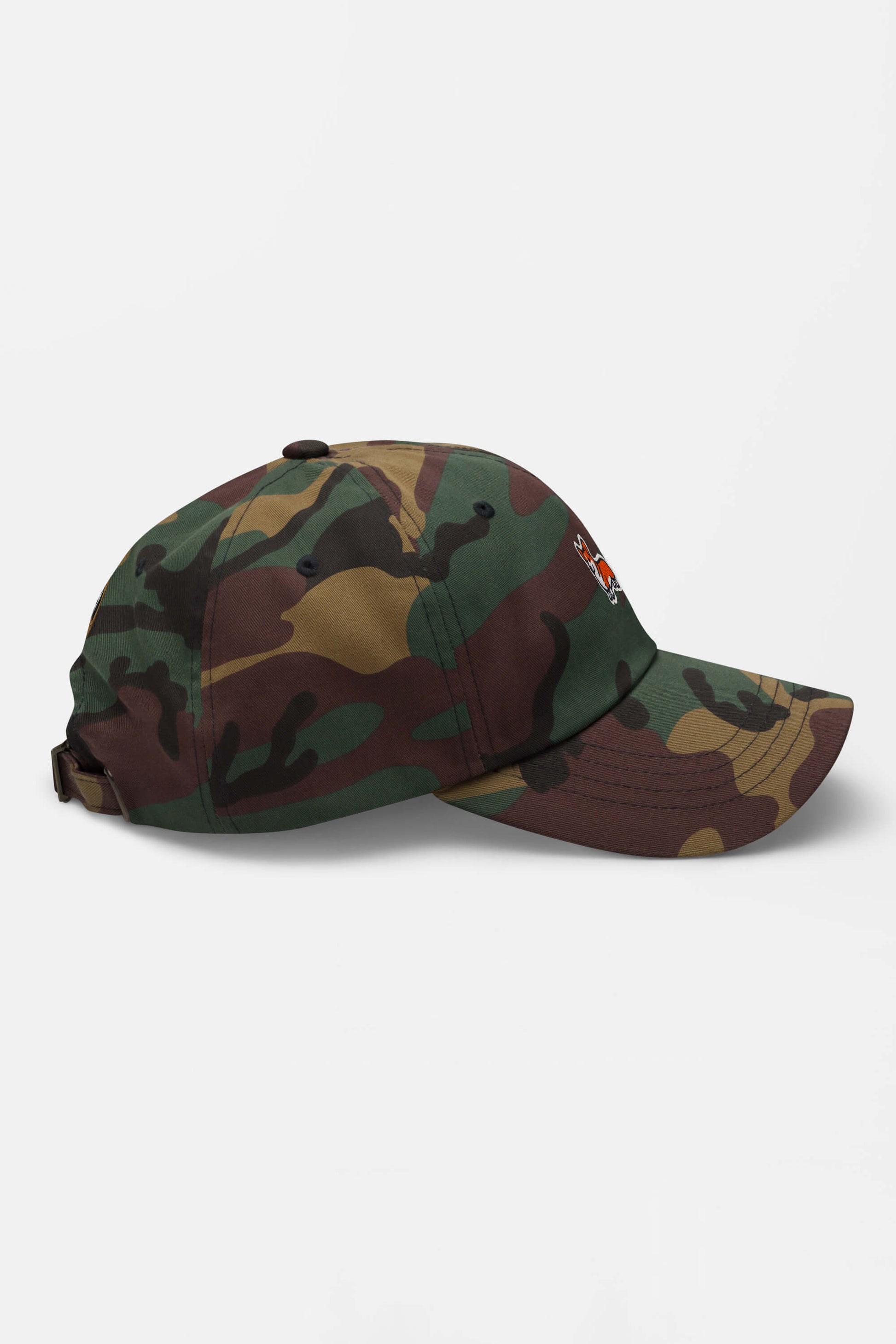The Iconic Corgi Cap by Dogloverclothing.com features a green, brown, and tan camouflage design, with a curved brim and adjustable strap—ideal for showcasing Corgi charm on any adventure. Shown side view on a white background.