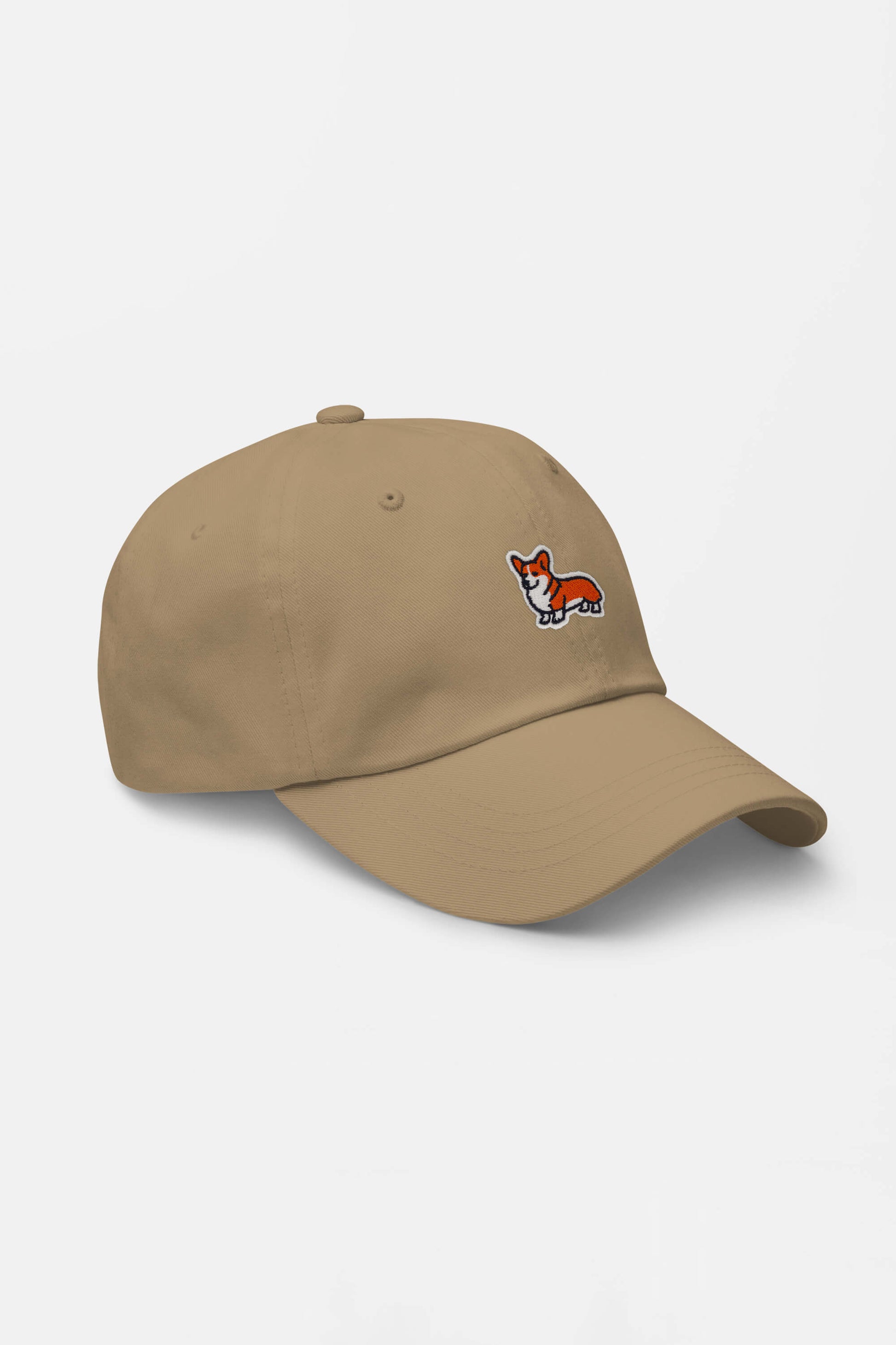 The Iconic Corgi Cap from Dogloverclothing.com is a tan hat with a small embroidered cartoon corgi dog on the front, perfect for showing off ultimate Corgi cuteness.