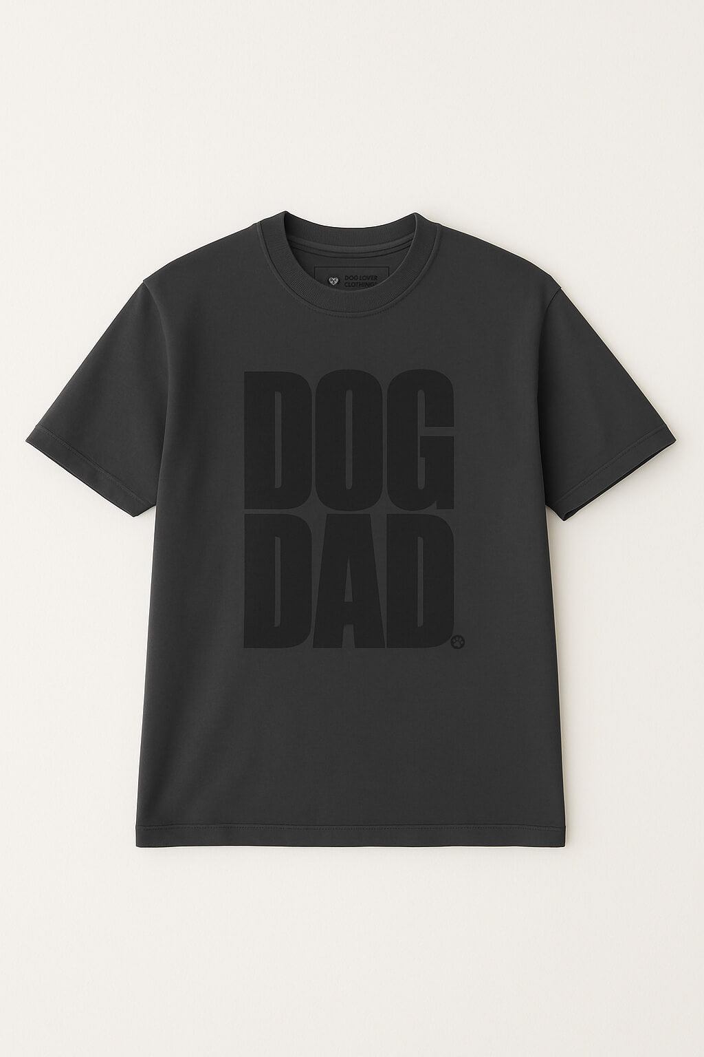 The Oversized Dog Dad T-Shirt by Dogloverclothing.com is a plain black cotton tee with bold DOG DAD text on the front, offering a stylish and comfortable fit. Displayed against a light background.